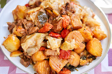 Dimlama - stewed vegetables with the meat in a large Central Asian cauldron. Uzbek cuisine. Fried vegetables with meat. Outdoor lunch, picnic