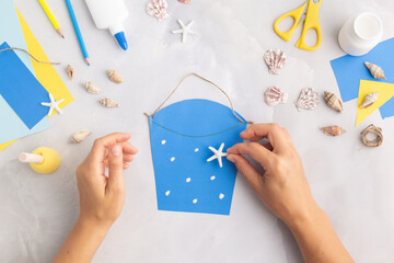 Paper bucket of shells summer idea for kids craft in kindergarten hands ocean's day © Angelina Zinovieva