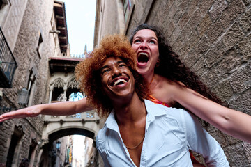 young couple of tourist doing piggiback and having fun in gothic quarter, Barcelona, Spain - Travel...