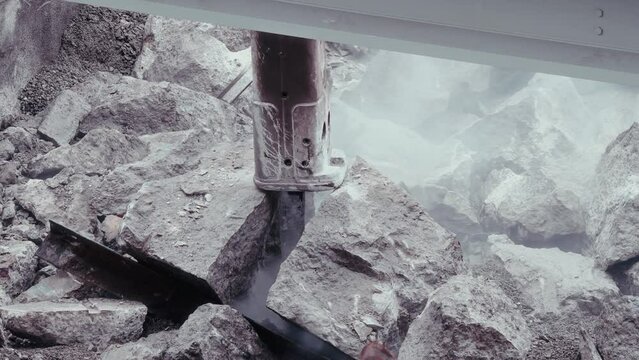Close-ups of hydraulic rock breakers crushing bridge debris. This 4K footage embodies infrastructure repair, spotlighting the raw force that reshapes our built environment