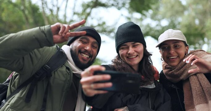 Friends, happy or hikers taking a selfie while hiking outdoors in nature sharing the experience on social media. Winter, forest or active people take a picture or a photo while trekking together