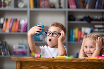 School boy dreaming with alarm clock in classroom