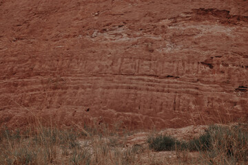 Mud wall, Argilosa mountain and dry bushes.