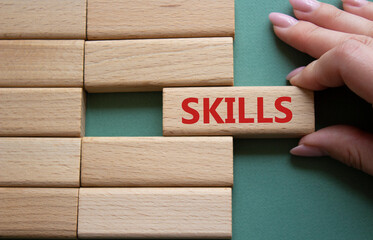 Skills symbol. Concept word Skills on wooden blocks. Businessman hand. Beautiful grey green background. Business and Skills concept. Copy space.