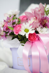 European bouquet of flowers in a purple basket. Fresh bouquet of flowers of orchids, roses, alstramerias. Flower shop. Master classes and floristry courses. Flower delivery.