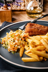 Fried cod fillet with fries and salad.