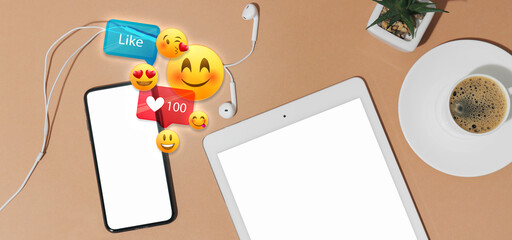 Mobile phone and tablet computer with blank screens and social network reactions on beige background