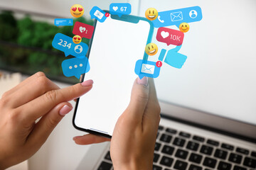 Woman with mobile phone chatting online at workplace