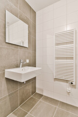 a modern bathroom with white tile walls and flooring, along with a wall mounted mirror above the sink basin