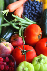 Wooden crate full of healthy seasonal fruit and vegetable. Selective focus, dark background.