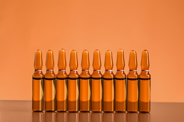 Medical ampules on orange background