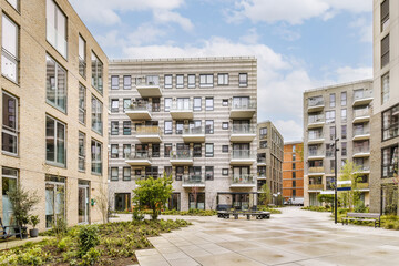 some buildings that are in the middle of an urban area with trees and bushes on either side of the street