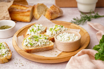 Sandwiches with tasty cottage cheese and green onion on table