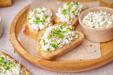 Sandwiches with tasty cottage cheese and green onion on table