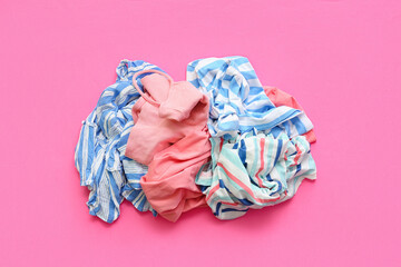 Pile of dirty clothes on pink background