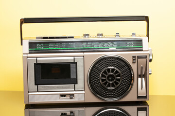 Obraz premium Silver retro ghetto radio boom box cassette recorder from 80s on a yellow background.
