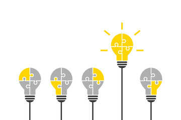 Light bulb made of jigsaw puzzle pieces as smart and outstanding idea concept. Standing out, good thinking, solution, innovation and success concept with bright yellow lightbulb symbol. 
