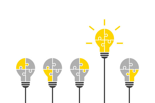 Light bulb made of jigsaw puzzle pieces as smart and outstanding idea concept. Standing out, good thinking, solution, innovation and success concept with bright yellow lightbulb symbol. 