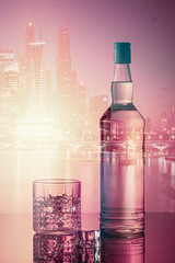 Bottle of liquor with the city skiline in the background at night.