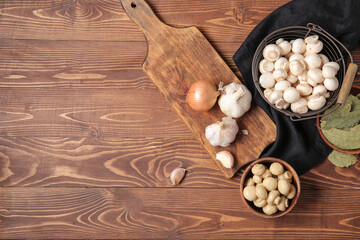 Canned and fresh mushrooms with ingredients for preservation on wooden background