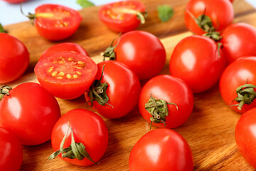 Wooden board with fresh cherry tomatoes, closeup