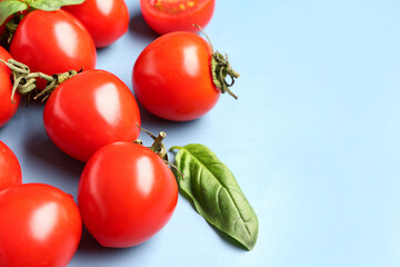 Fresh cherry tomatoes and basil on blue background