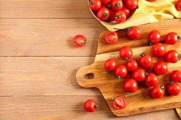 Naklejka na ściany i meble Board and bowl with fresh cherry tomatoes on wooden table
