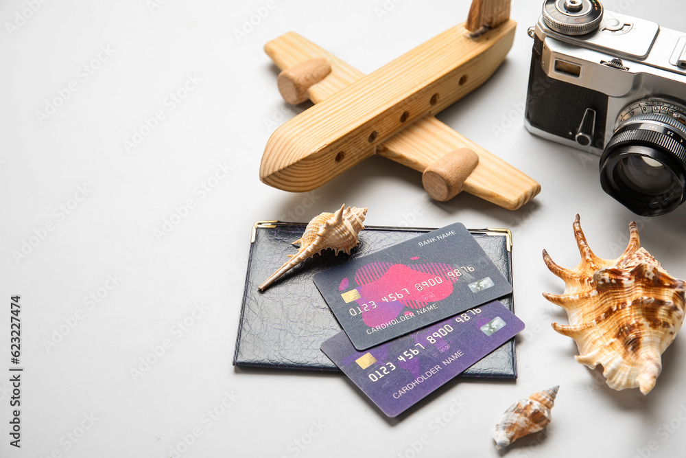 Sticker Credit cards, passport, wooden plane and seashells on white background