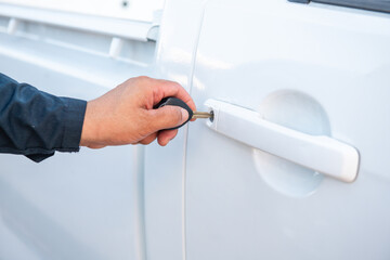 A mechanic man inserting car key in car door