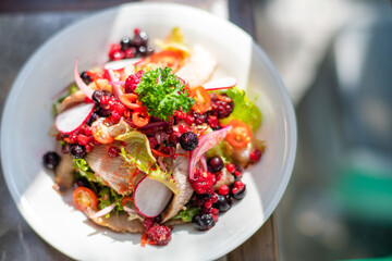 Red Mix Salad with grilled pork on white plate ontop with fruit