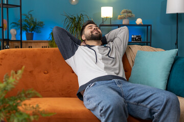 Tired man lying down on comfortable couch, taking a rest, daytime nap. Portrait of carefree...