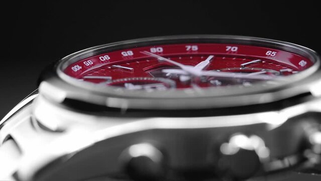 Close Up Of Stylish Man Wrist Watch With Moving Hand And Multiple Dials. Men's chronograph watch in metal with sapphire crystal. closeup view of rotating watch, running second arrow. red watch dial