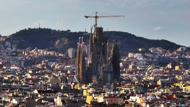 Aerial cinematic footage of famous cathedral in construction. Sagrada Familia at golden hour. Barcelona, Spain