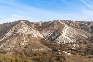 Lifeless brownish rocky hills in winter sunshine