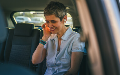 One mature caucasian woman senior female put ear buds while sit in car
