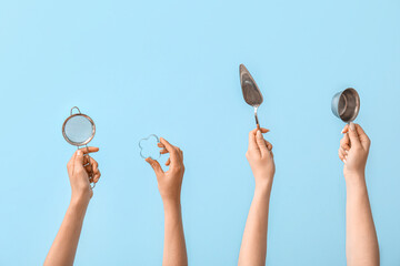 Female hands with baking utensils on blue background