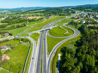 New highway junction in Poland on national road no 7, E77, called Zakopianka.  Overpass crossroad with traffic circles, slip ramps and viaducts near Rabka. Road E77 to Slovakia to the right - obrazy, fototapety, plakaty