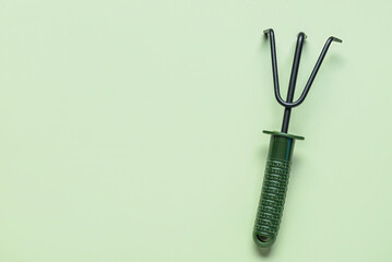Gardening rake on green background