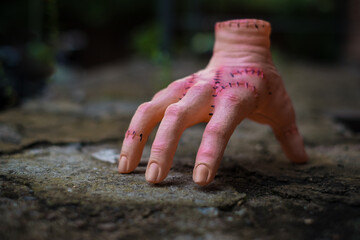 Scary realistic human hand with scars and stiches. Cut off hand with active fingers. Plastic toy.