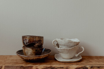 Handmade ceramic cups on a wooden shelf