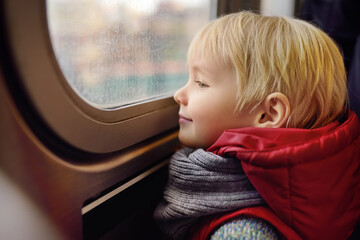 Little boy looks out the window of the car in the subway in New York, USA.