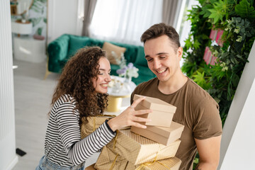 man and woman give gift box presents at home holiday surprise concept
