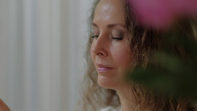 An attractive perfumer girl sniffs a jar of aroma oil and chooses a fragrance for herself. The concept of creating your own natural fragrance