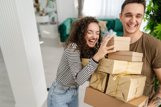 man and woman give gift box presents at home holiday surprise concept