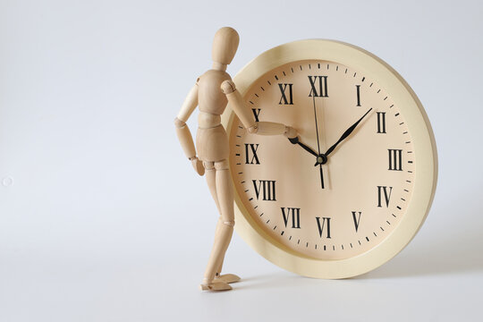 The wooden man turns the clock back