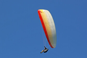Paraglider flying in a blue sky	