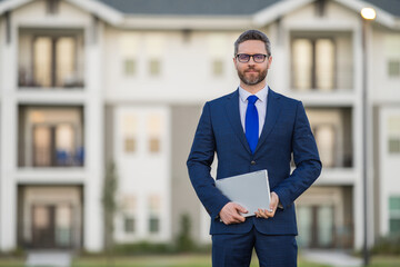 Business man hold laptop outdoor near home. Hispanic man with laptop outdoor. Businessman hold laptop computer front of house background. Entrepreneur with a laptops, business man using laptop.