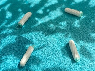 Sanitary tampons lie on a blue blanket. Cleanliness, care, care. The harm of tampons during menstruation