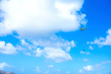 Rescue helicopter carrying water from ocean to fire site