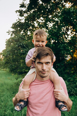 happy family child on dad's neck for a walk